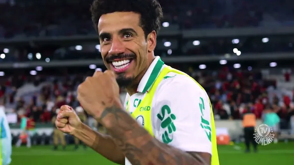 Jogador do Palmeiras de colete comemora na Arena da Baixada