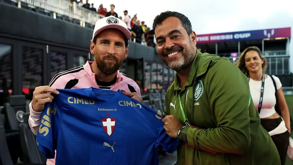 Lionel Messi segura a camisa azul do Palmeiras ao lado de João Paulo Sampaio, em Miami