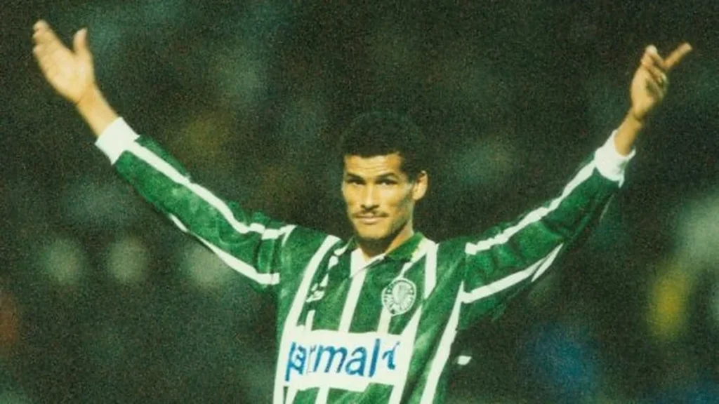 Rivaldo comemora com os braços abertos usando a camisa do Palmeiras dos anos 1990